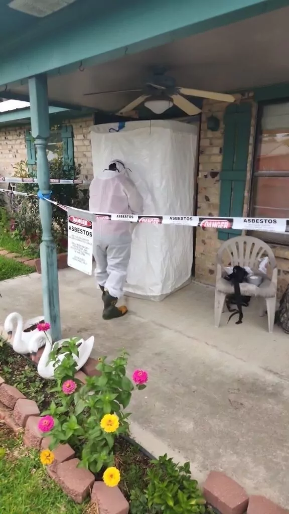 A professional entering a house in need of asbestos removal services.